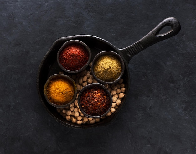 Pois chiches crus, épices et piquant. Ingrédients pour le plat indien Chole ou Chana Masala ou Pois chiches épicés dans des bols.