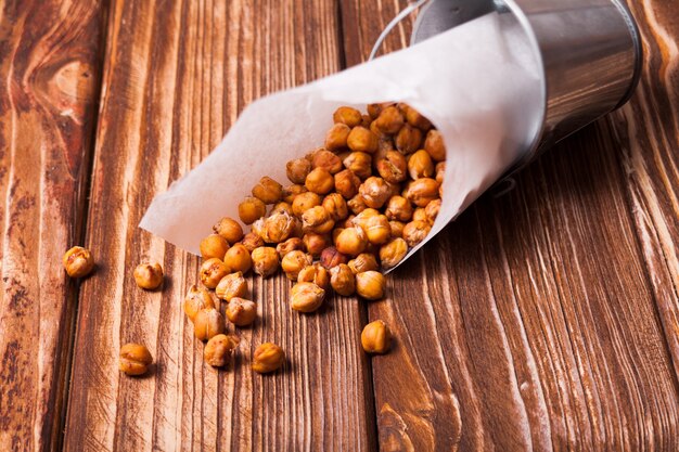 Pois chiches cuits épicés dans un seau en métal sur le fond en bois