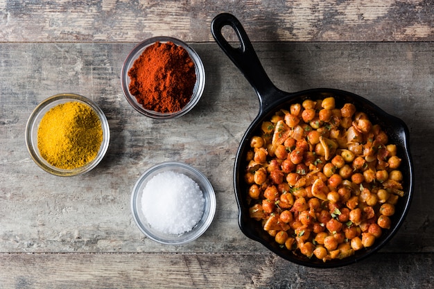 Pois chiches épicés frits dans une poêle sur une table en bois Vue de dessus