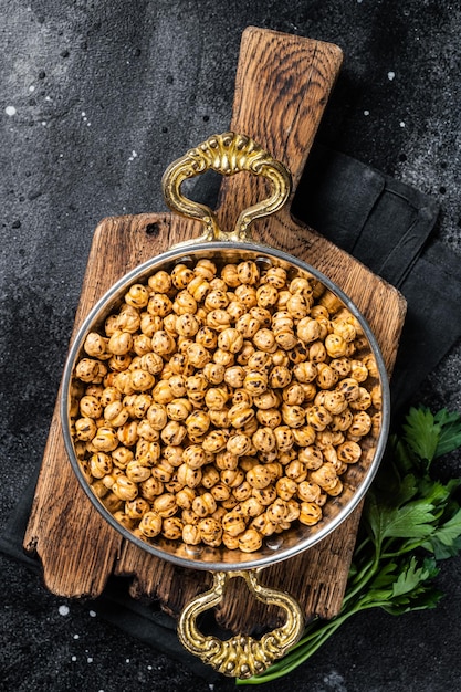 Pois chiches frits avec pois chiches épicés rôtis au curcuma ou chana indien ou chole dans une poêle Fond noir Vue de dessus