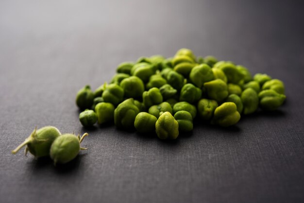 Pois chiches verts frais OU Hara Harbara servis dans un bol ou une assiette sur fond de mauvaise humeur. mise au point sélective