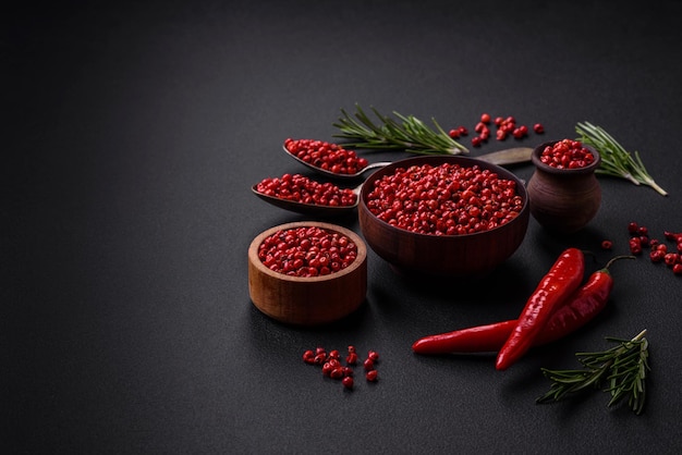 Pois épicés de piment de la Jamaïque de couleur rouge ou rose dans un bol en bois