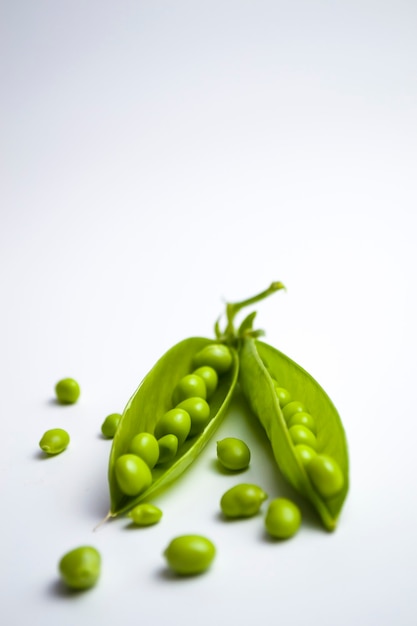 Pois verts en cosses sur fond blanc nourriture végétarienne saine