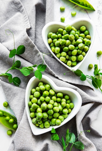 Pois verts dans des bols en forme de coeur