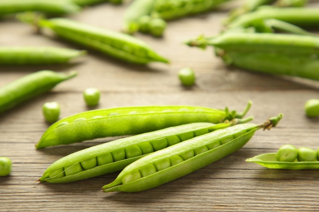 Pois verts frais et copieux sur fond de bois rustique. Vue de dessus