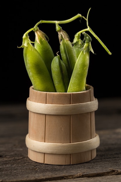 Pois verts frais dans un bol en bois.