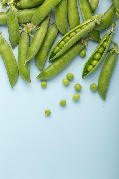 Pois verts frais sur fond bleu Mise à plat Vue de dessus