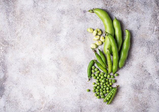 Pois verts frais et haricots sur fond clair