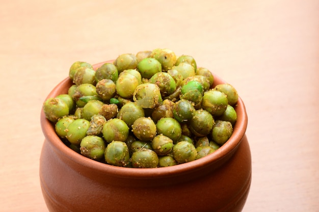 Pois verts frits épicés (chatpata matar) Snack indien. Pois verts salés séchés en pot d'argile.