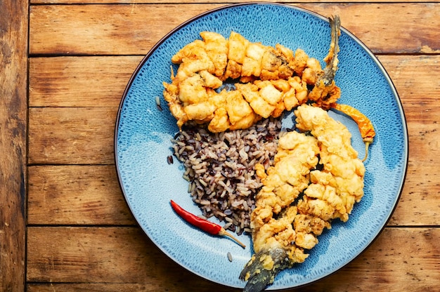 Poisson de bar frit avec du riz sur papier de riz Fruits de mer rôtis