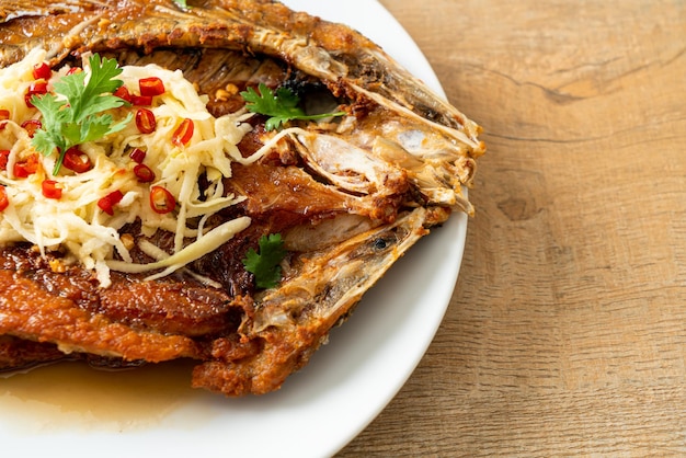 Poisson de bar frit avec sauce de poisson et salade épicée