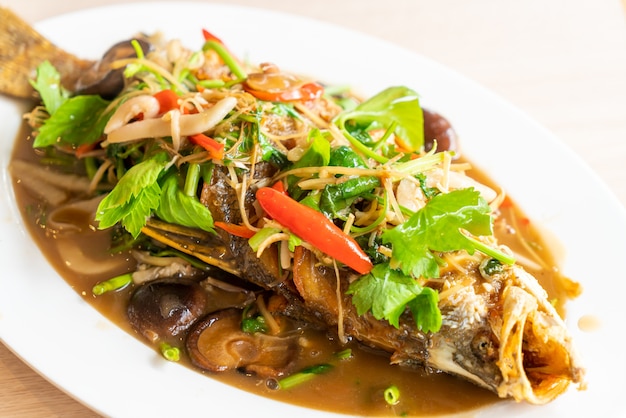 Poisson de bar frit avec sauce sucrée et garnitures