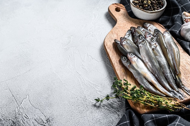 Poisson capelan cru sur planche à découper