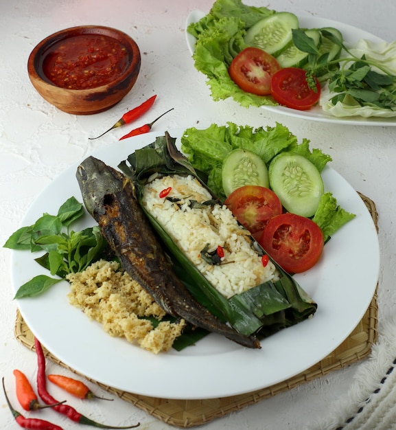 Poisson-chat frit avec riz sambal complet avec légumes et piment