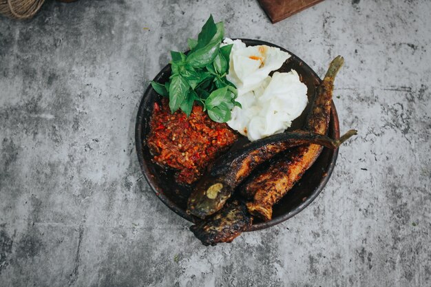 poisson-chat grillé avec sauce chili et légumes frais