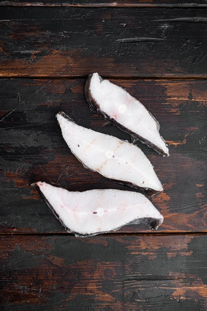 Poisson congelé coupé sur la vieille vue de dessus de fond de table en bois sombre mise à plat