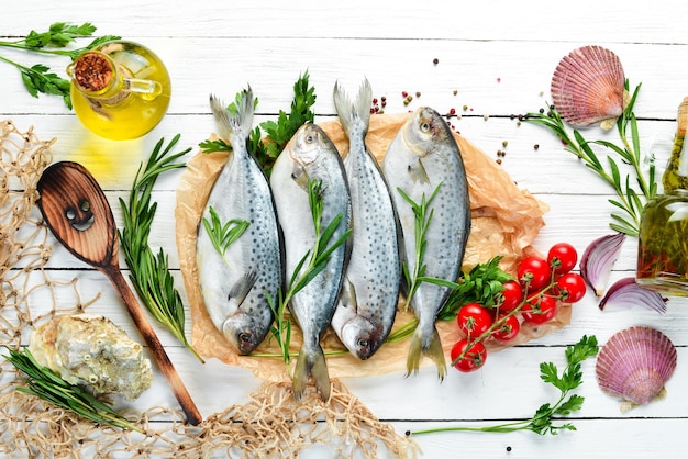 Poisson cru au sel de citron et au romarin Sur un fond en bois blanc Vue de dessus Espace de copie gratuit