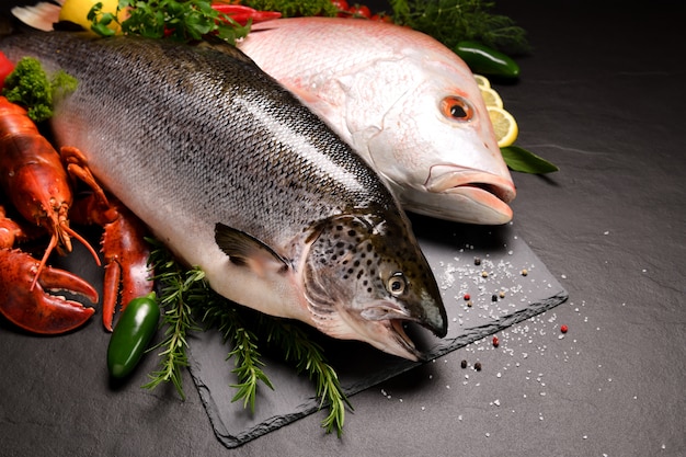 Poisson cru frais et fruits de mer disposés sur une surface en pierre noire