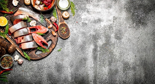 Poisson cru. Un morceau de saumon frais aux épices sur une vieille planche à découper. Sur la table rustique.