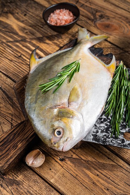 Poisson cru Sunfish ou pompano sur une planche en bois