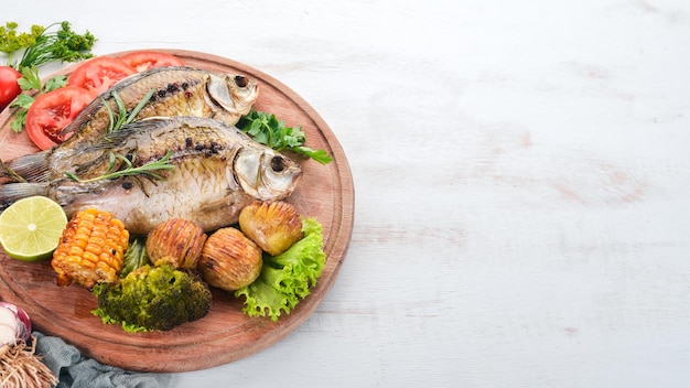 Poisson cuit au four avec des épices et des légumes Carpe Sur un fond en bois Vue de dessus Espace de copie