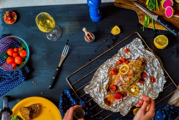 Poisson cuit au four avec des légumes sur la table avec différents légumes et herbes Le concept d'une alimentation saine