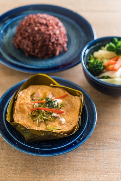 poisson cuit à la vapeur avec de la pâte de curry et du riz aux baies