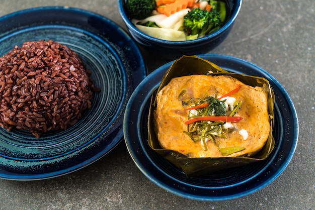 poisson cuit à la vapeur avec de la pâte de curry et du riz aux baies