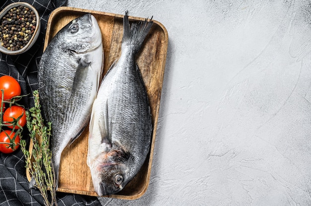 Poisson de daurade cru avec des ingrédients de cuisine tomates cerises