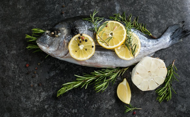 Poisson dorado cru aux épices Dorado et ingrédients pour cuisiner sur une table