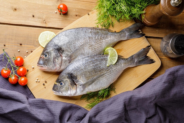 Poisson dorado cru pelé avec ingrédients de cuisson Poisson frais sur fond de bois