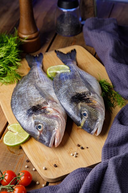 Poisson dorado cru pelé avec ingrédients de cuisson Poisson frais sur fond de bois