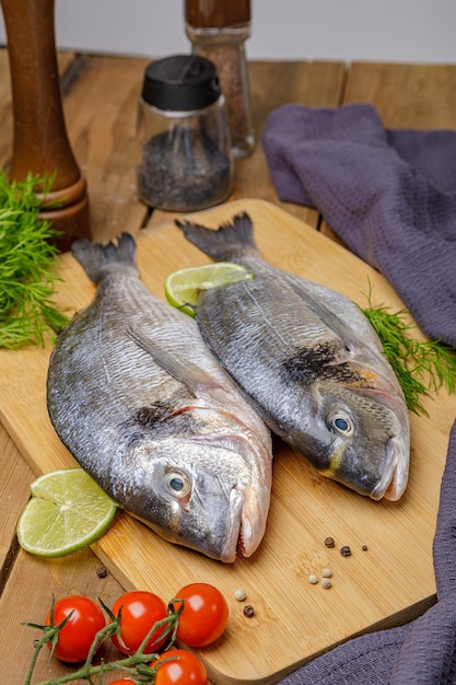 Poisson dorado cru pelé avec ingrédients de cuisson Poisson frais sur fond de bois