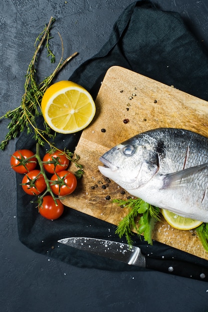 Photo poisson dorado farci sur une planche à découper en bois.