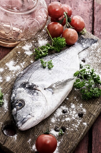 Poisson dorado frais sur une table en bois