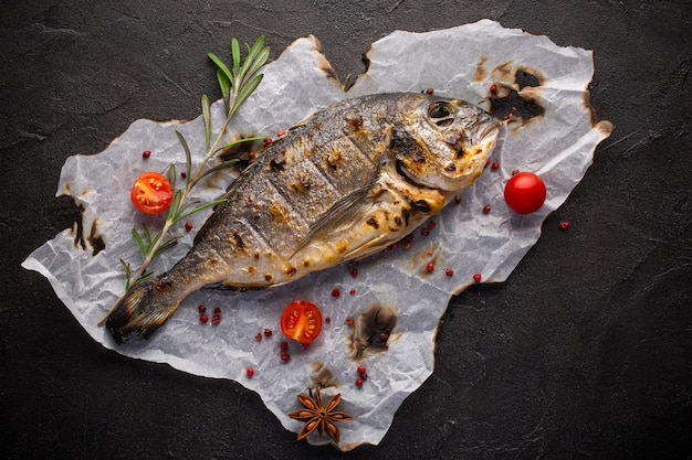 Poisson dorado frit aux épices sur fond noir