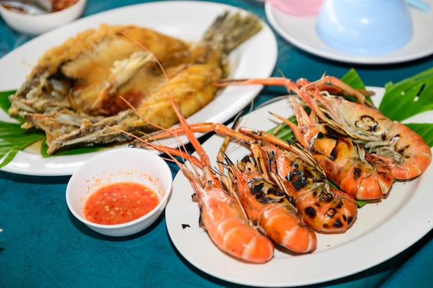 Le poisson frais et les crevettes sur la plage deviennent un menu de poisson frit avec sauce de poisson et délicieuse grille