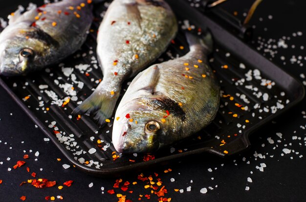 Poisson frais Dorado cru sur une poêle en fer