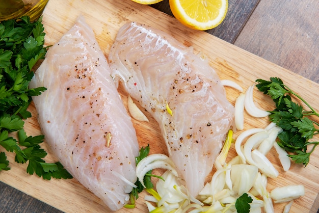 Poisson frais, filets de morue crus avec addition d&#39;herbes et de citron