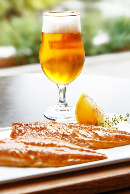 Poisson frais grillé et un verre de bière fraîche dans un café en plein air