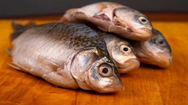 Poisson frais pelé, carassin sur la planche.