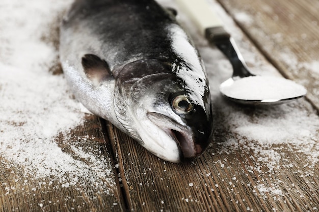 Poisson frais et sel en cuillère sur fond de bois