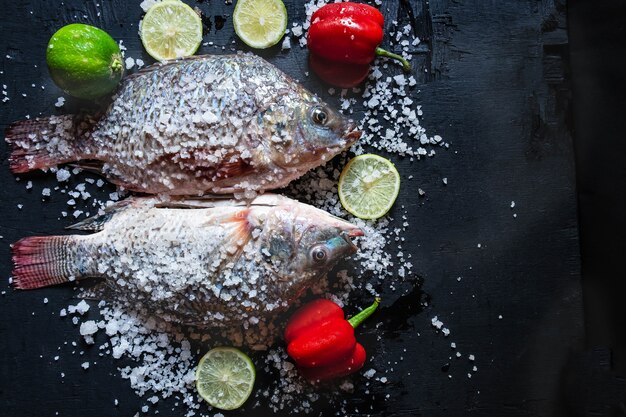 Poisson frais de tilapia au sel et assaisonnement pour la cuisson.