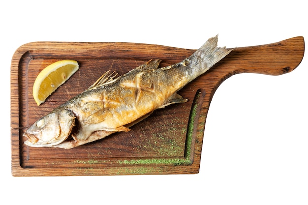 Poisson frit appétissant au citron sur une planche de bois