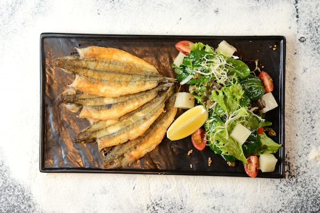 Photo poisson frit avec salade et citron