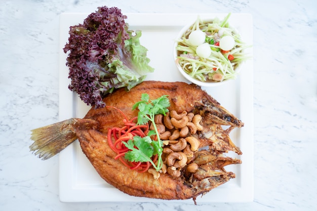 Poisson frit avec salade épicée. Style de la cuisine thaïlandaise