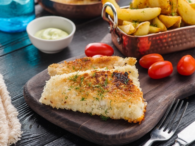 Poisson frit avec sauce tomate-olive et pommes de terre.