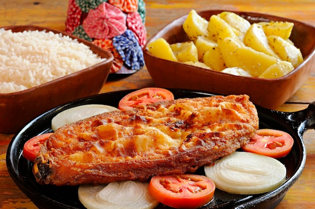 Poisson frit en steak avec oignon et tomate avec riz et pommes de terre Plat du nord-est brésilien