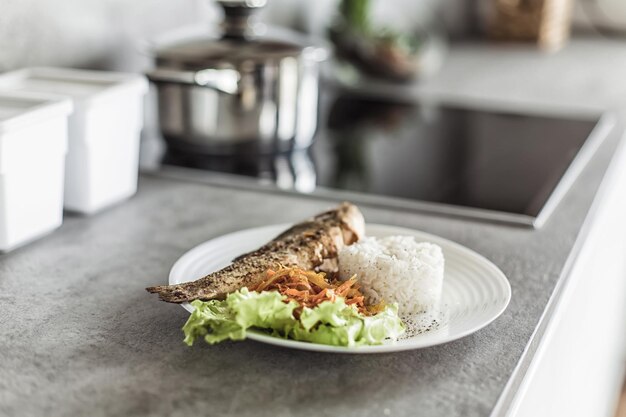 Poisson avec garniture sur la table de la cuisine