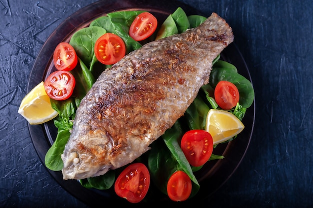 Poisson grillé aux épinards tomates sur une planche de bois dîner délicieux et léger